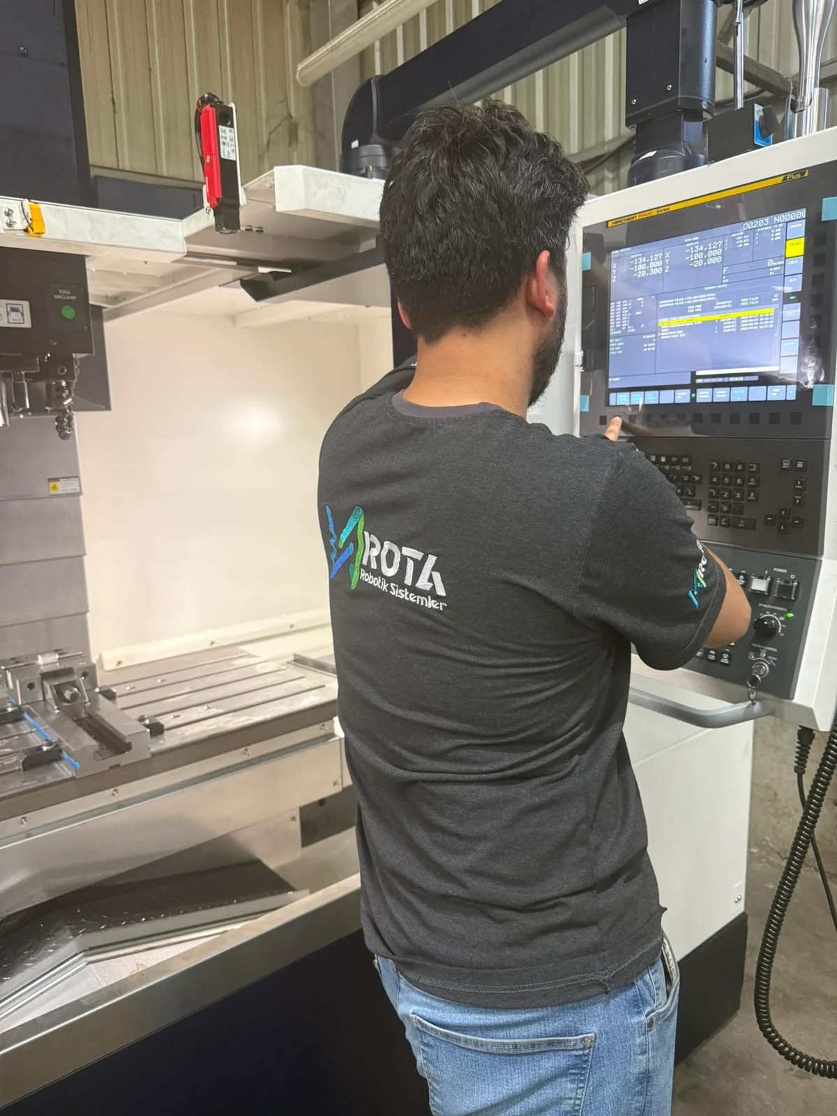 Rota Robotik operator at a CNC machine control panel